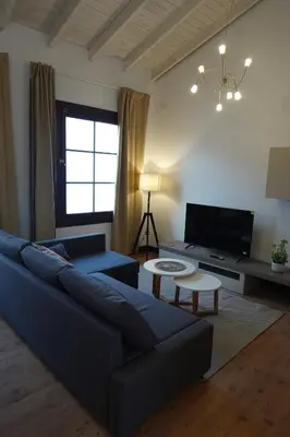 a living room with a blue couch and a tv at Apartamento Casa Dalí in Jerez de la Frontera