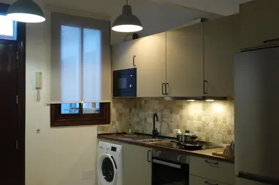 a kitchen with white cabinets and a washing machine at Apartamento Casa Dalí in Jerez de la Frontera