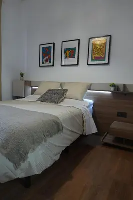 a bedroom with a bed with three pictures on the wall at Apartamento Casa Dalí in Jerez de la Frontera