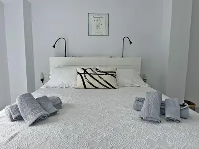 a white bed with three pillows on top of it at Apartamento San Miguel - Ole Solutions in Jerez de la Frontera