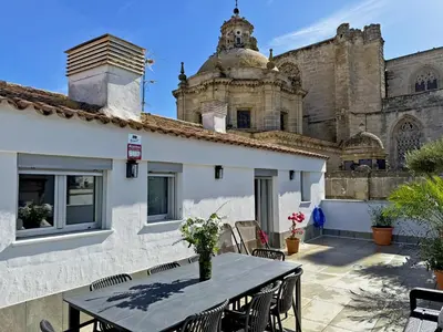 a patio with a table and chairs in front of a building at Apartamento San Miguel - Ole Solutions in Jerez de la Frontera