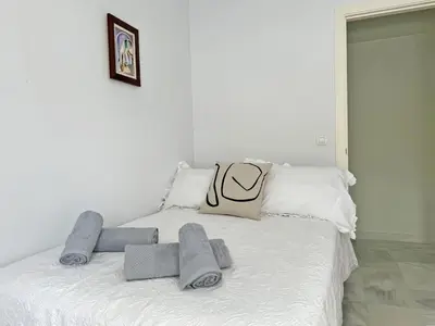 a white bed with towels on top of it at Apartamento San Miguel - Ole Solutions in Jerez de la Frontera