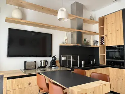 a kitchen with a table with chairs and a tv at Atico Torre Tavira Ascensor Grupo AC Gestion in Cádiz