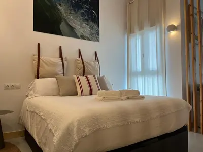 a bedroom with a large bed with white sheets at Atico Torre Tavira Ascensor Grupo AC Gestion in Cádiz