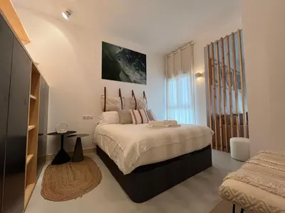 a bedroom with a large bed and a window at Atico Torre Tavira Ascensor Grupo AC Gestion in Cádiz