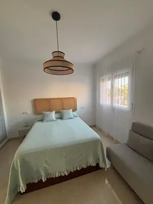 a bedroom with a bed and a lamp and a couch at Soto de Vistahermosa in El Puerto de Santa María