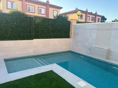 a swimming pool in front of a house at Soto de Vistahermosa in El Puerto de Santa María