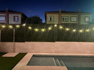 a fence with lights on it next to a house at Soto de Vistahermosa in El Puerto de Santa María