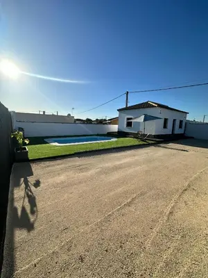 a house with a road in front of a building at Alojamiento Carlota in Chiclana de la Frontera