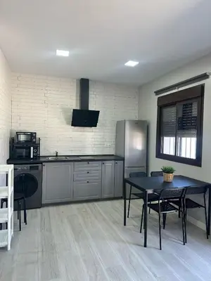 a kitchen with a table and a refrigerator at Alojamiento Carlota in Chiclana de la Frontera