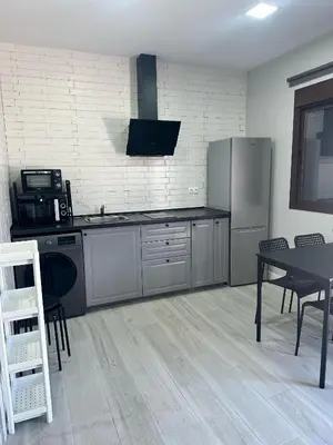 a kitchen with a refrigerator and a table with chairs at Alojamiento Carlota in Chiclana de la Frontera