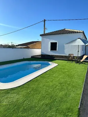 a swimming pool in a yard next to a house at Alojamiento Carlota in Chiclana de la Frontera