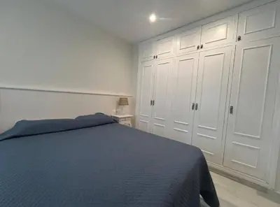 a bedroom with a blue bed and white cabinets at Apartoyou - Vistahermosa Lux in El Puerto de Santa María