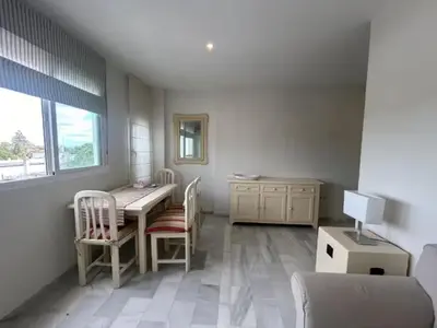 a room with a desk and a table and chairs at Apartoyou - Vistahermosa Lux in El Puerto de Santa María