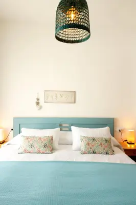 a bed with a blue headboard and two pillows at La Bodega del Mar - Luminoso y céntrico apto con piscina en verano y parking in El Puerto de Santa María