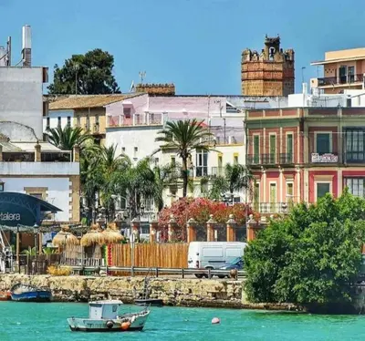 a boat in a body of water next to buildings at Apartamento Danubio in El Puerto de Santa María