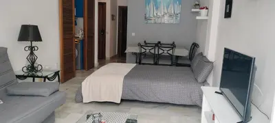 a living room with a bed and a couch at Apartamento Danubio in El Puerto de Santa María