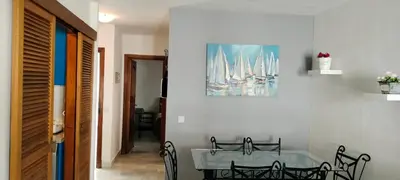 a dining room with a table and chairs and a painting at Apartamento Danubio in El Puerto de Santa María