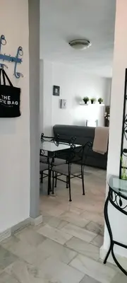 a living room with a table and a piano at Apartamento Danubio in El Puerto de Santa María