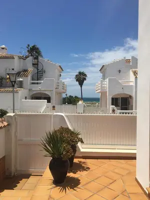 a bedroom with two beds and a table with a lamp at Casa en Sancti Petri junto a playa La Barrosa in Chiclana de la Frontera