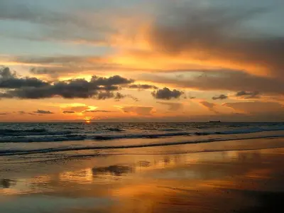 a sunset on a beach with the ocean at Casa en Sancti Petri junto a playa La Barrosa in Chiclana de la Frontera