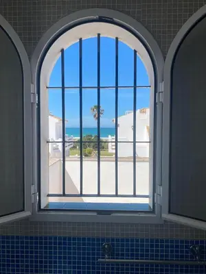 a house with a white fence and a potted plant at Casa en Sancti Petri junto a playa La Barrosa in Chiclana de la Frontera