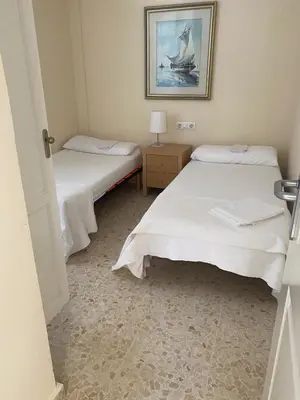 two beds in a room with a picture on the wall at Casa en Sancti Petri junto a playa La Barrosa in Chiclana de la Frontera