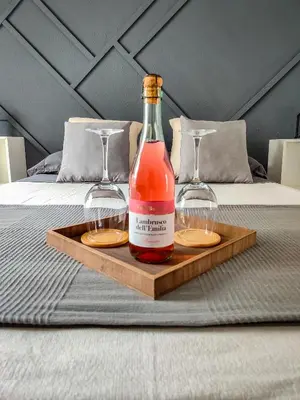 a bottle and two glasses on a tray on a bed at ESCAPADAS ROMÁNTICAS Gavira Apartamento in Rota