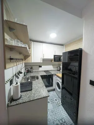 a kitchen with white cabinets and a sink at ESCAPADAS ROMÁNTICAS Gavira Apartamento in Rota