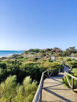 a wooden porch with a view of the ocean at sunset at ESCAPADAS ROMÁNTICAS Gavira Apartamento in Rota