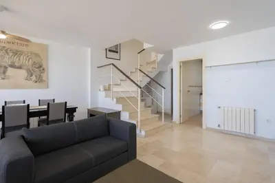 a living room with a couch and a staircase at Apartoyou - Breva Playa in El Puerto de Santa María