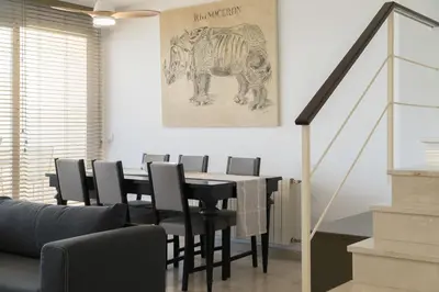 a dining room with a black table and chairs at Apartoyou - Breva Playa in El Puerto de Santa María
