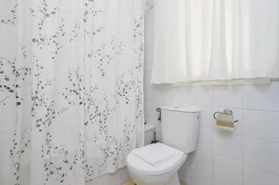 a bathroom with a toilet and a shower curtain at Apartoyou - Breva Playa in El Puerto de Santa María