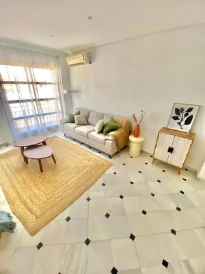 a living room with a couch and a table at ÁTICO Centro y Playa in Sanlúcar de Barrameda