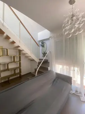 a white room with a staircase and a chandelier at Sanlúcar mar in Sanlúcar de Barrameda