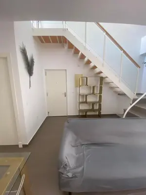 a living room with a staircase and a chair at Sanlúcar mar in Sanlúcar de Barrameda