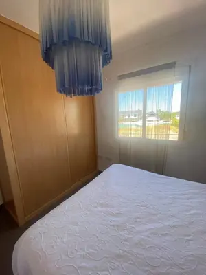 a bedroom with a bed with blue curtains and a window at Sanlúcar mar in Sanlúcar de Barrameda
