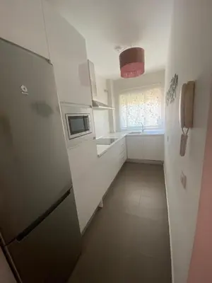 a small kitchen with a refrigerator and a sink at Sanlúcar mar in Sanlúcar de Barrameda
