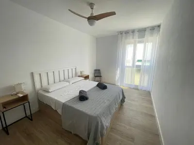 a white bedroom with a bed and a ceiling fan at La Isla Centro in San Fernando