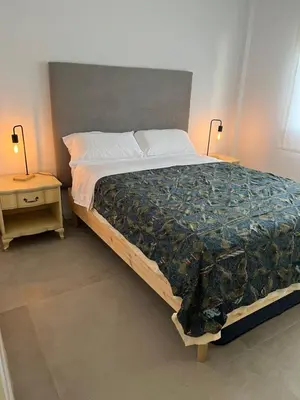 a bedroom with a large bed and two night stands at La Fontaniega in Cádiz