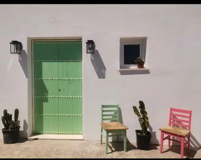 a green door and two chairs and a table at La Fontaniega in Cádiz
