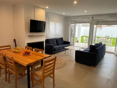 a living room with a table and chairs and a television at La Fontaniega in Cádiz