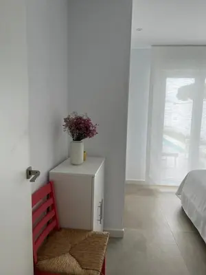 a white cabinet with a plant on it in a bedroom at La Fontaniega in Cádiz