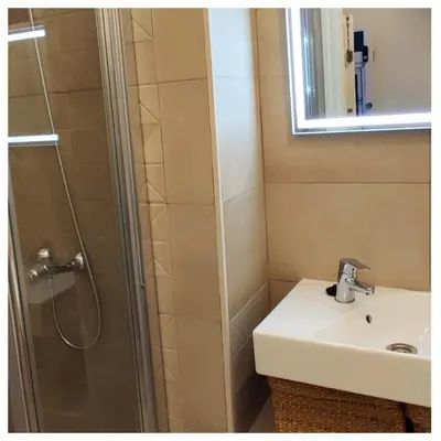 a bathroom with a sink and a shower with a mirror at LA BARAKA APARTAMENTO in Jerez de la Frontera