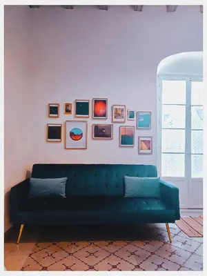 a living room with a green couch against a white wall at LA BARAKA APARTAMENTO in Jerez de la Frontera