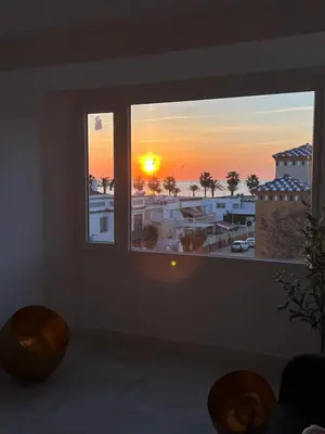 a room with a window with a view of a sunset at Sibs Sanlúcar Atlantico Playa Vistas Reformado in Sanlúcar de Barrameda