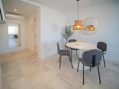 a dining room with a table and chairs at Sibs Sanlúcar Atlantico Playa Vistas Reformado in Sanlúcar de Barrameda
