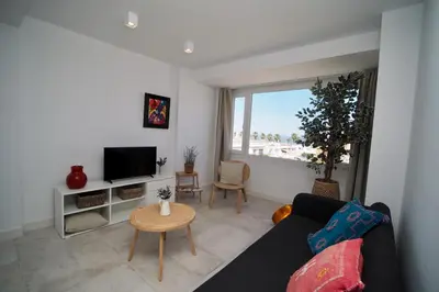 a living room with a couch and a tv at Sibs Sanlúcar Atlantico Playa Vistas Reformado in Sanlúcar de Barrameda