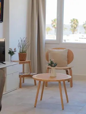 a living room with a chair and a table at Sibs Sanlúcar Atlantico Playa Vistas Reformado in Sanlúcar de Barrameda