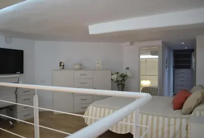 a white room with a bed and a desk at Apartamento en Playa Victoria in Cádiz